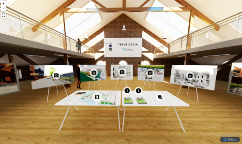 Screenshot of the virtual consultation room for Trent Basin. There is a table in the centre of the room showing a map of the development, and there are boards around the room perimeter displaying CGI renders and drawings of the plans.